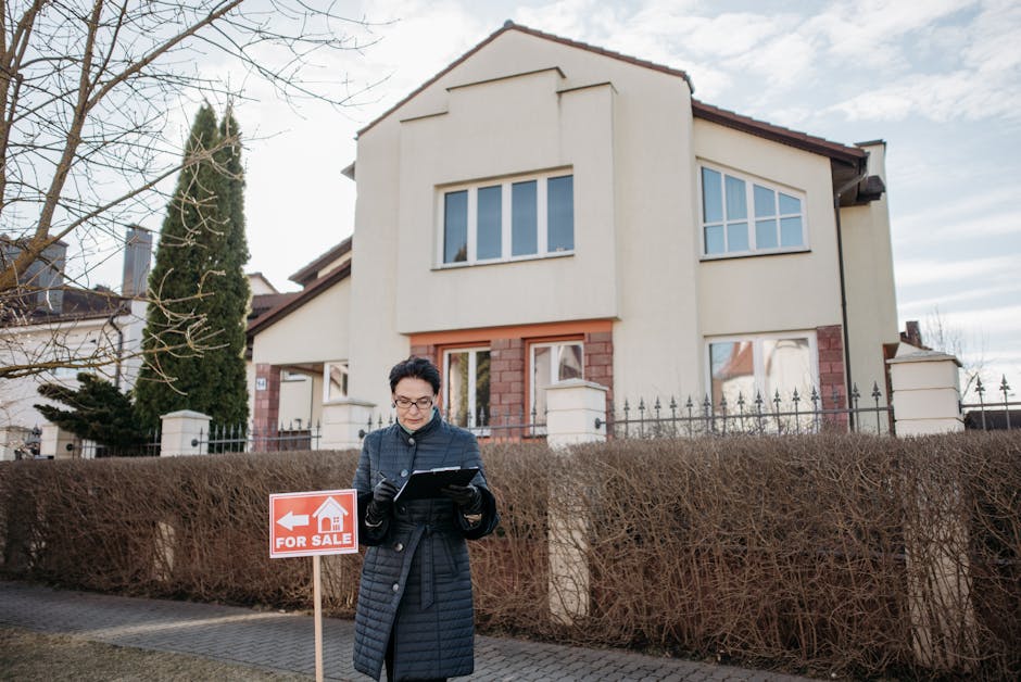 A real estate agent standing outside a house with a 'For Sale' sign, ready for viewing.